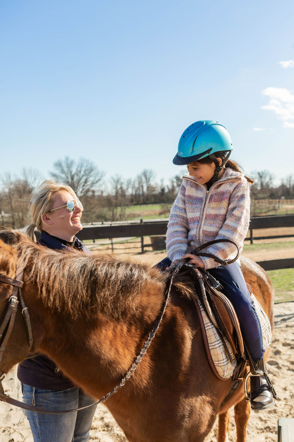 Olivia and a young rider sharing a smile during a lesson