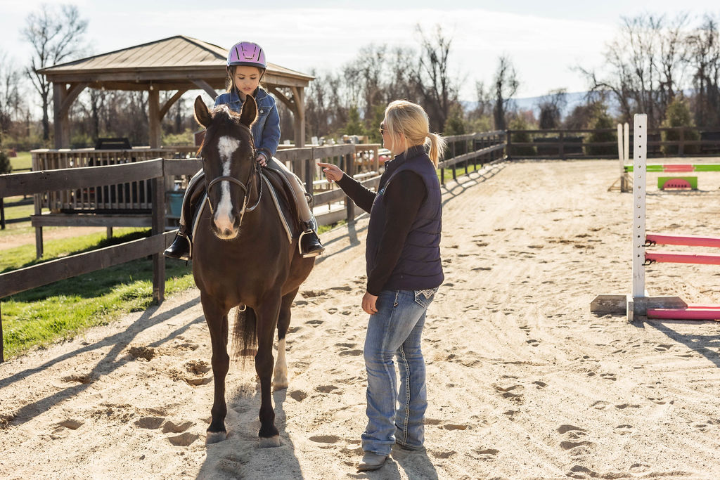 Olivia instructing a young rider during a lesson at Serene Acres